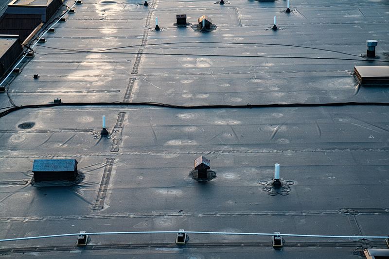 Membrane being laid on an apartment building flat roof